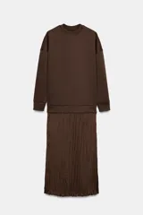 Vestido midi de manga larga, con parte superior tipo buzo de tejido liso color marrón oscuro y falda larga plisada de tejido satinado marrón oscuro.