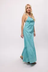 Vestido largo color celeste, de tirantes finos y espalda descubierta. Presenta volados en el ruedo y escote fruncido.