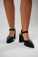 Sandalias negras de charol con punta cuadrada, tira sobre el empeine con hebilla metálica y tacón ancho.