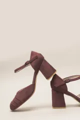 Zapato de tacón de terciopelo verde con correa al tobillo, punta redondeada y tacón cuadrado.