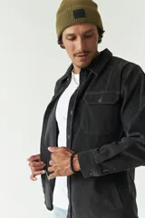 Sobrecamisa color beige de pana con cuello camisero, cierre frontal con botones, dos bolsillos de parche con botón en el pecho y bolsillos laterales.