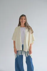 Ruana color crudo con flecos en el ruedo.