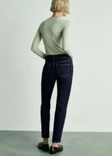 Pantalón de jean azul oscuro, tiro alto, corte mom fit, con cinco bolsillos y cierre de cremallera y botón.