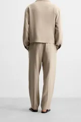 Pantalón negro de corte recto con cintura elástica, bolsillos laterales y un bolsillo trasero de ojal.