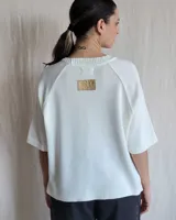 Sweater color beige de tejido de punto con mangas cortas y cuello redondo.