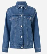 Campera trucker de jeans azul oscuro, corte amplio, con cuello clásico, cierre frontal con botones blancos, mangas largas y bolsillos delanteros con solapa.