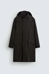 Trench relaxed fit negro confeccionado en tejido técnico ligeramente acolchado, con cuello subido y capucha desmontable. Tiene manga larga, bolsillos de vivo en pecho y de solapa en cadera, y abertura en el centro de la espalda. El cierre frontal es con cremallera oculta por solapa con botones a presión.