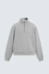 Sudadera gris de algodón con cuello alto y cremallera frontal corta. Corte relaxed fit, manga larga y terminaciones en rib.