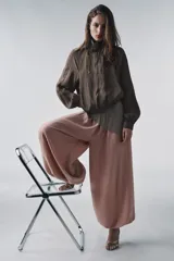 Pantalón bombacho de lyocell color rosa pálido, con cintura elástica y lazos ajustables en los tobillos.
