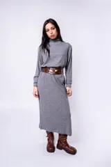 Vestido midi gris de punto, con cuello alto y mangas largas. Incluye cinturón ancho de cuero marrón con hebilla metálica.