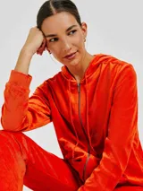 Campera naranja de plush con capucha, cierre frontal y bolsillos tipo canguro.