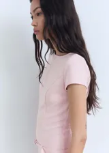 Vestido corto rosado de corte entallado, con cuello redondo y mangas cortas. Presenta un cinturón decorativo a la altura de la cintura y cierre invisible en la espalda.