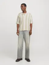 Polo de manga corta color crema con rayas verticales en relieve color verde claro. Tiene cuello clásico y cierre frontal con botones.