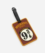 Tag de valija marrón y amarillo con forma rectangular y correa negra. Estampa de la plataforma 9 3/4 de Hogwarts.