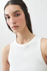 Musculosa color crudo de tejido de punto canalé, sin mangas y cuello redondo.