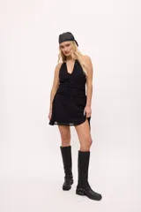 Minivestido negro con escote halter, espalda descubierta, cintura drapeada y falda con transparencias.