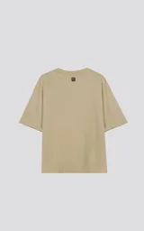 Remera color beige de corte crop y calce oversize, con hombros caídos y cuello redondo.