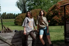 Remerón verde militar de corte holgado, con cuello redondo y estampado de sol y luna en tonos marrones.