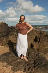 Musculosa tejida color marrón con diseño calado y flecos en los hombros.