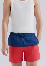 Shorts de baño con diseño bicolor, azul en la cintura y rojo en la parte inferior. Cuenta con cintura elástica y cordón ajustable.