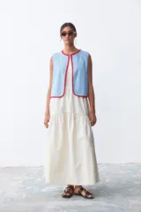 Chaleco celeste de denim con terminaciones en crochet rojo.