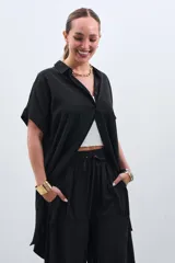 Camisola negra de tencel con cuello camisero, manga corta y cierre frontal con botones.