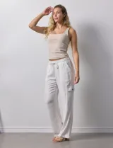 Pantalón cargo de lino color blanco, marca Marissa Olivia. Tiene pretina ancha elastizada con lazo de ajuste, bolsillos inclinados delanteros y bolsillos laterales con botón.