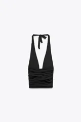 Top negro de cuello halter ajustable con lazadas, espalda descubierta, detalle de aplicación metálica en el delantero y drapeado lateral.
