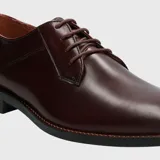 Zapato de vestir formal de cuero color bordó, con cordones y suela de goma.