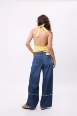 Pantalón de jean crudo, de corte recto y tiro bajo, con doble pasacinto y ajuste con lazo.