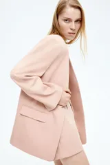 Blazer color rosa viejo de sarga, corte oversized, sin cuello, con pinzas delanteras, bolsillos ribeteados con solapa y abertura en los puños.