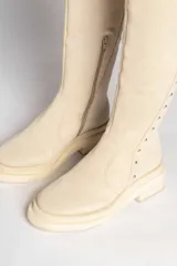 Botas bucaneras negras de gamuza con apliques de tachas doradas.