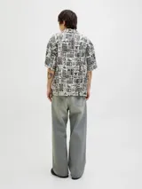 Camisa de manga corta con cuello resort y fit amplio. Confeccionada en tejido plano con estampado de motivos marinos y tropicales en blanco y negro.