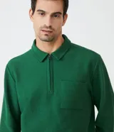 Buzo verde de algodón para hombre, modelo comfort con cuello polo con cremallera, mangas largas, bolsillo frontal y puños ajustados.