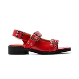 Sandalias rojas de cuero con hebillas plateadas y taco bajo cuadrado negro.