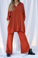Pantalón color ladrillo de corte palazzo, con cintura elástica y tajos laterales en el ruedo.