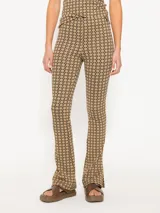 Pantalón de tiro alto con estampado geométrico en tonos beige y negro, de corte ajustado y acampanado en el ruedo.