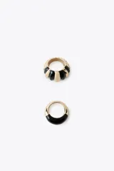 Pack de dos anillos dorados con esmalte negro: uno con diseño abultado a rayas y otro liso con detalle de esmalte en la mitad superior.