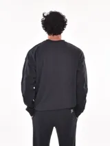 Buzo deportivo negro de corte regular, con cuello redondo y mangas largas.
