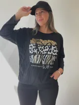 Remera negra de algodón con estampado de animal print en dorado, plateado y gris.