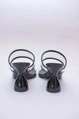 Sandalias plateadas con taco de forma geométrica y tiras transparentes.