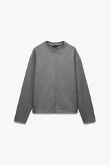 Sweater gris de cuello redondo en rib, manga larga y corte holgado.