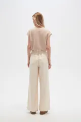 Pantalón de jean color beige, de tiro alto, corte palazzo y estilo paper bag.