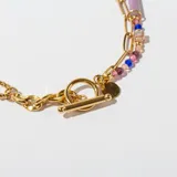 Collar dorado de doble cadena, una de eslabones y otra con cuentas de colores y dije circular.