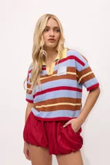 Remera tejida con rayas horizontales marrones, rosas y turquesas, cuello polo y calce boxy.