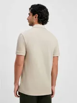 Camiseta tipo polo de manga corta, color azul oscuro, con cuello y tapeta de dos botones.