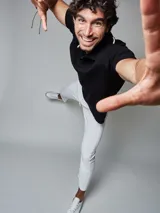 Remera tejida tipo polo color negro, de corte regular fit, con cuello y puños con ribete en contraste de color blanco, cartera con tres botones y logo bordado en la pechera.