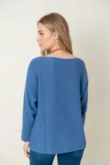 Sweater de lana color beige, de corte holgado y mangas largas.