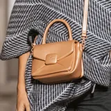 Cartera bandolera color rosa gold, con solapa y diseño acolchado en símil cuero. Tiene correa regulable y asa fija, herrajes plateados, bolsillo interno con cierre, bolsillo externo abierto y compartimento principal con interior de tela de algodón y poliéster.