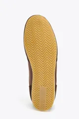 Zapatillas deportivas marrones con detalles en gamuza y talón en blanco. Cierre con cordones y suela de goma color hueso.